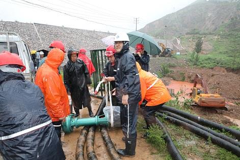 圖一為中州鋁業(yè)保障中心員工冒雨在現(xiàn)場搬運(yùn)潛水泵設(shè)備，以應(yīng)對未來幾天更加嚴(yán)峻的汛情。